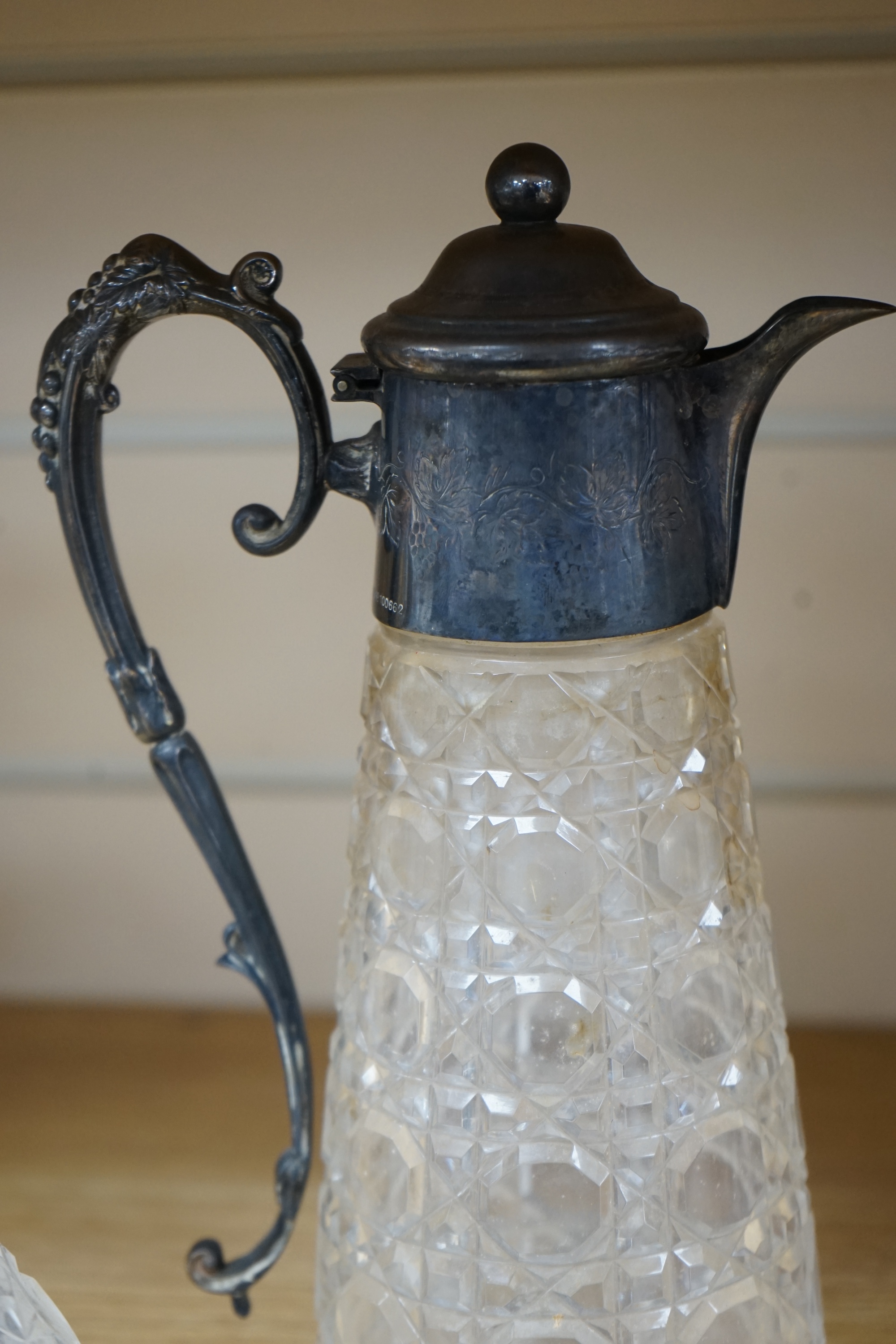 An Edwardian silver mounted cut glass decanter and stopper, London, 1901, height 26cm, together with a silver plate mounted cut glass claret jug. Condition - poor to fair